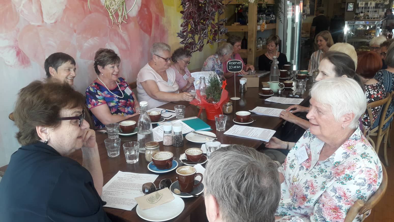 A table of guests chatting over coffee at a café